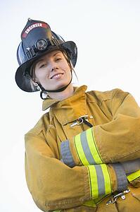 Firewoman standing outdoors wearing helmet