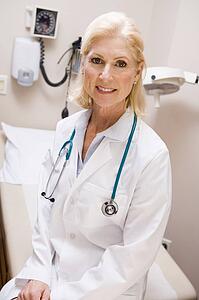 Middle Aged Female Doctor Sitting In A Hospital Ward