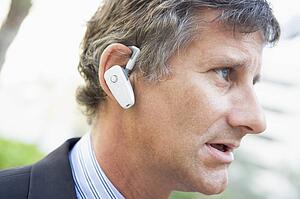 Businessman wearing earpiece outdoors
