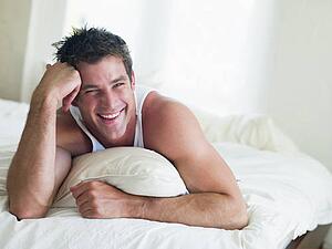 Man lying in bed smiling