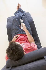 Man sitting in chair using remote control
