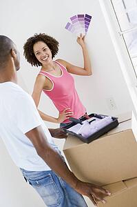 Couple with paint swatches in new home smiling