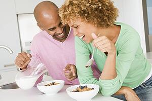 Husband And Wife Eating Breakfast Together