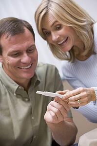 Couple with pregnancy test smiling (selective focus)