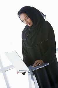 Woman indoors standing with laptop (high key/selective focus) 