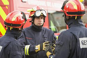 Three rescue workers talking by rescue vehicle