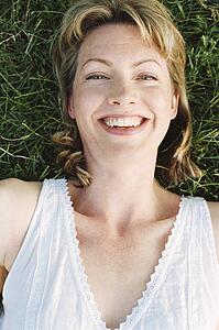 Woman lying outdoors smiling