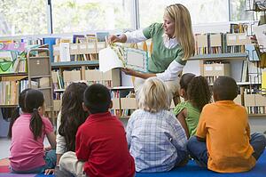 Teacher in class reading to students
