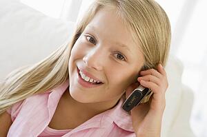 Young Girl Sitting On A Sofa Talking On A Cellphone