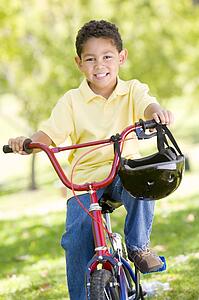 Young boy on bicycle outdoors smiling