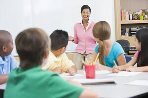 Students in class with teacher lecturing (selective focus)