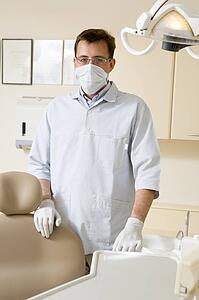 Dentist in exam room with mask on