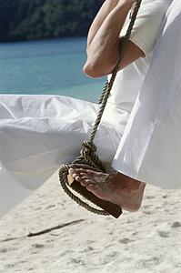 Couple on a swing outdoors at the beach (selective focus)