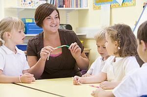 Students in math class using counting beads (selective focus)
