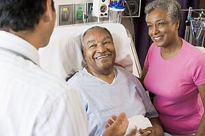 Senior Couple Talking, Smiling With Doctor