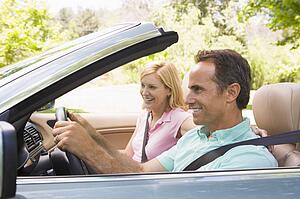 Couple in convertible car smiling