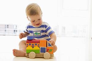 Baby indoors playing with truck