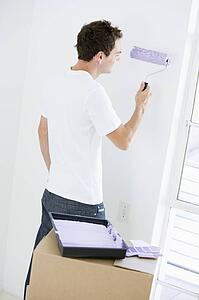 Man painting room in new home smiling