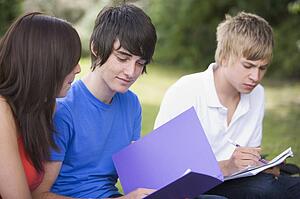 Three students outdoors studying (selective focus)