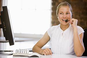Businesswoman wearing headset in office smiling