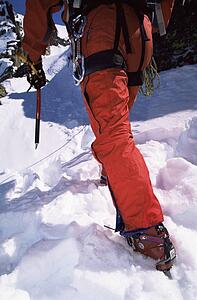 Mountain climber going up snowy mountain (selective focus)