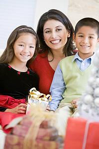 Mother With Her Son And Daughter Holding Christmas Gifts