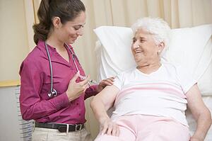 Doctor giving needle to woman in exam room smiling