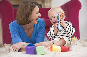 Mother in living room playing with baby smiling