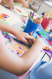 Students in art class focusing on hands (selective focus)