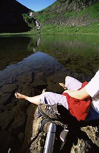 Woman's legs outdoors at campsite on large rocks
