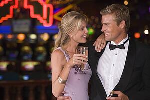Couple in casino with cigar and champagne smiling (selective focus)
