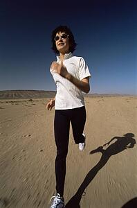 Woman outdoors running on the beach (blur)