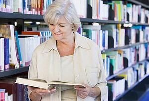 Woman in library reading book (depth of field)