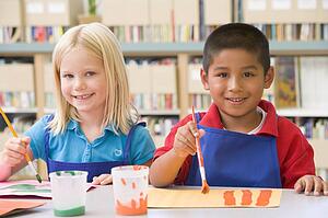 Two students in art class painting