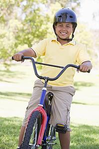 Young boy on bicycle outdoors smiling