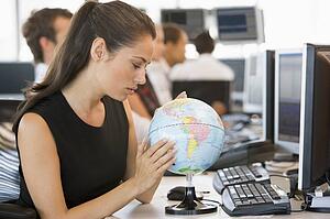 Businesswoman in office space with desk globe