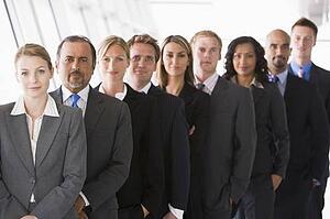 Group of co-workers standing in office space smiling (high key/depth of field)