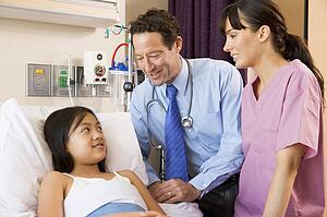 Doctor And Nurse Talking To Young Girl