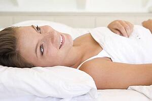 Woman lying in bed smiling