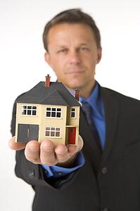 Businessman Holding Small House 