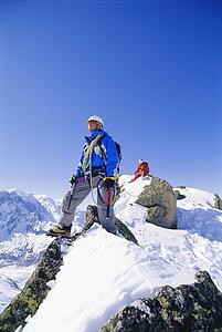 Two mountain climbers standing on snowy mountain