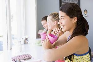 Three young women having a cold drink in a cafeteria