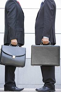 Two businessmen holding briefcases outdoors