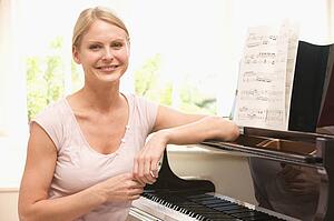 Woman sitting at piano and smiling
