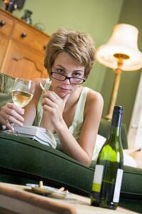 Young woman at home smoking and drinking wine by telephone