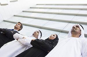 Four businesspeople standing outdoors by building (selective focus)