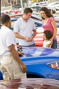 Mother Father and young daughter shopping for a new car