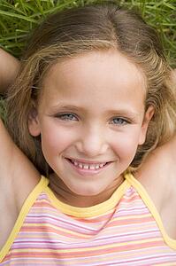 Young Girl Lying Down On The Grass