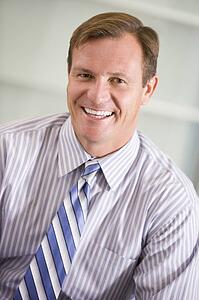 Businessman sitting indoors smiling