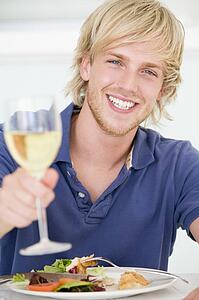 Young Man Enjoying meal, mealtime With A Glass Of Wine